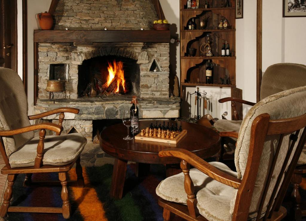 特立格拉德的住宿－阿爾坎韓酒店，客厅设有壁炉、棋盘和椅子