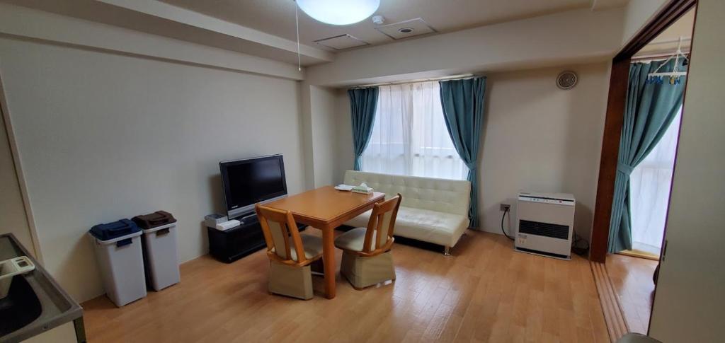a living room with a table and a couch at 札幌市中心部大通公園まで徒歩十分観光移動に便利なロケーションh203 in Sapporo
