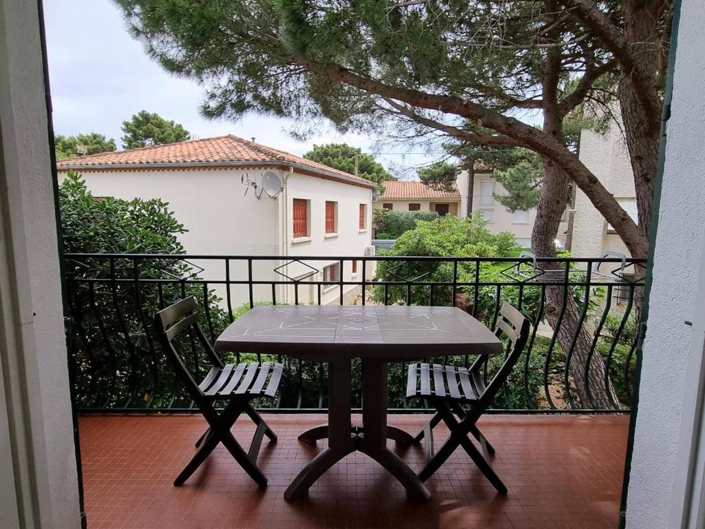 stół i krzesła na balkonie z widokiem na dom w obiekcie Studio confortable à 2 pas de la mer avec balcon - Argelès-sur-Mer - FR-1-388-209 w Argelès-sur-Mer