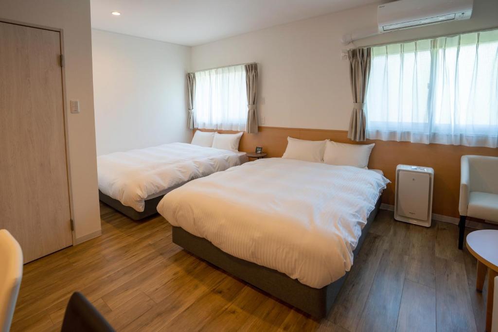 Postel nebo postele na pokoji v ubytování HOTEL R9 The Yard Honjo