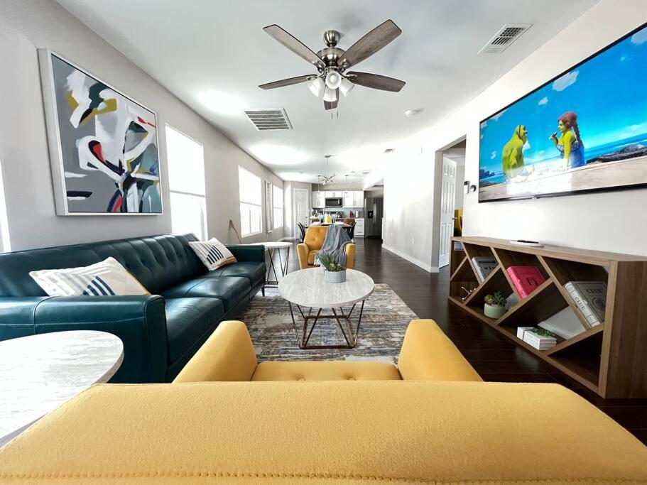 a living room with a blue couch and a flat screen tv at MODERN DOWNTOWN HOME CLOSE TO THE RIVERWALK, PEARL AND AT&T CENTER in San Antonio