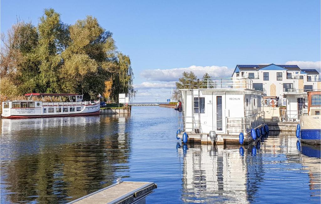 two boats are docked on a river with houses at 2 Bedroom Cozy Apartment In Rechlin in Rechlin