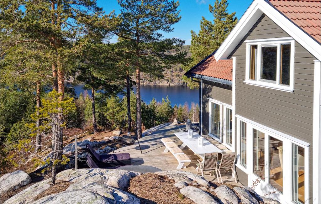 a view of a house with a patio and a lake at Lovely Home In Risør With Sauna in Risør