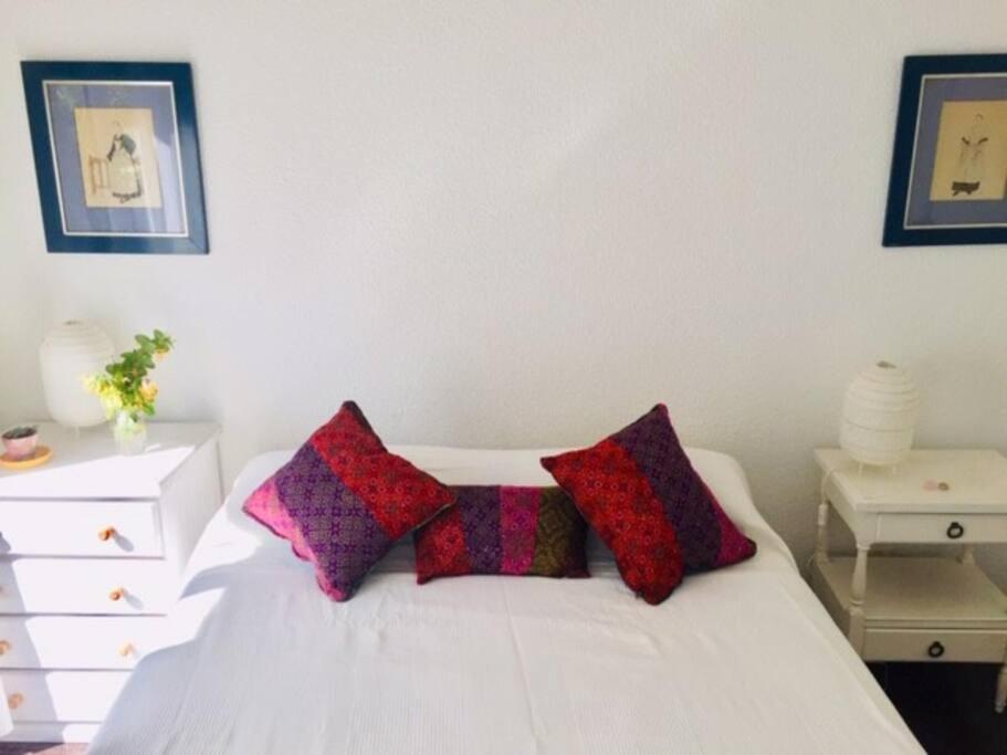 a bedroom with a white bed with two pillows on it at Lindo apartamento cerca del mar, Pinamar in Pinamar
