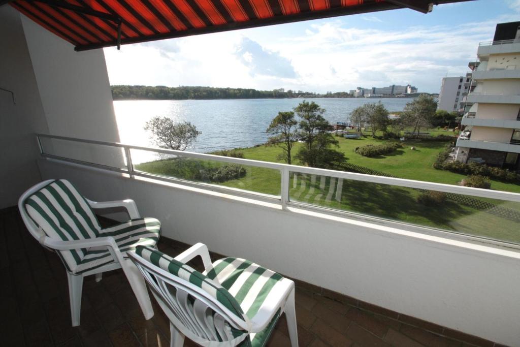 a balcony with two chairs and a view of the water at Steinwarder 1 - Haus "Seerose" ST1 034 Steinwarder 1 in Heiligenhafen