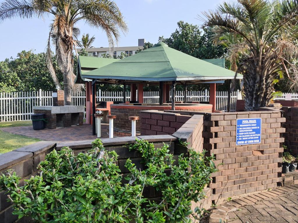 un cenador en un parque con palmeras en Unit 29, Dumela Holiday Resort, en Margate