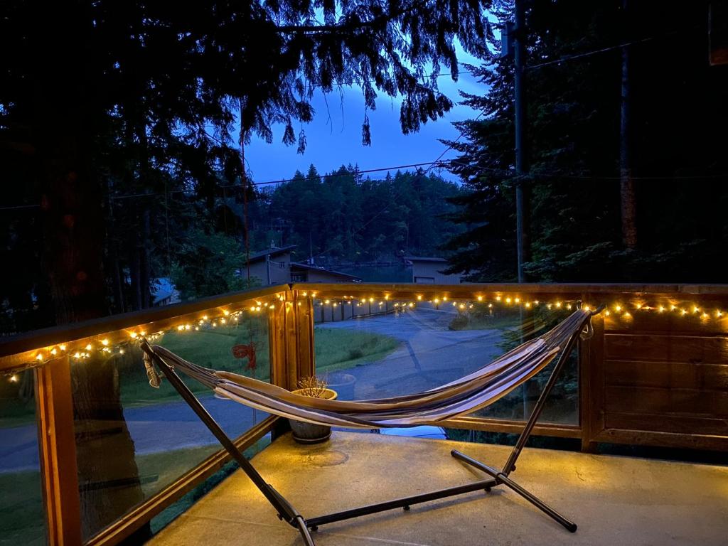 a hammock on a fence with lights on it at Cozy 2 bedroom cabin next to trails and beaches. in Pender Island