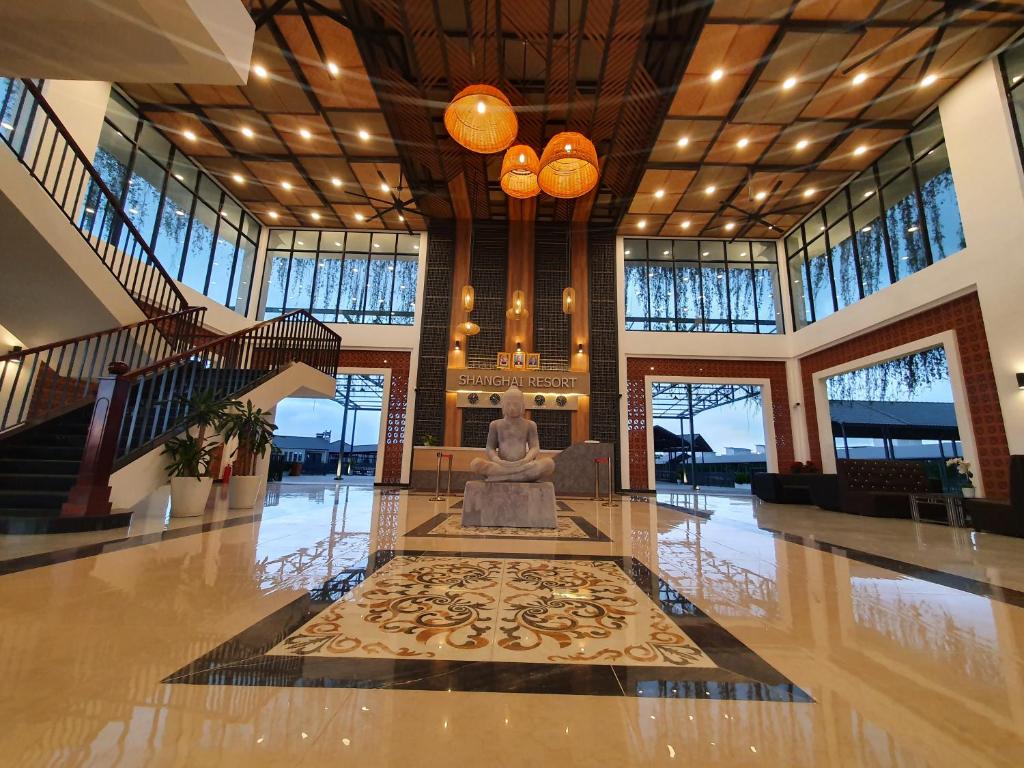 - un hall avec une statue au centre d'un immeuble dans l'établissement Shanghai Resort, à Bavet