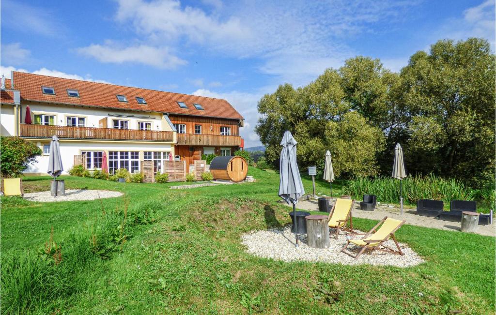 ein Haus mit einem Garten mit Stühlen und einem Sonnenschirm in der Unterkunft Nice Apartment In Viechtach With Kitchen in Viechtach