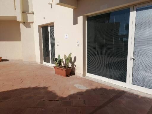 a patio with a large sliding glass door with a plant at Zibibbo Beach Apartments - Trapani in Trapani