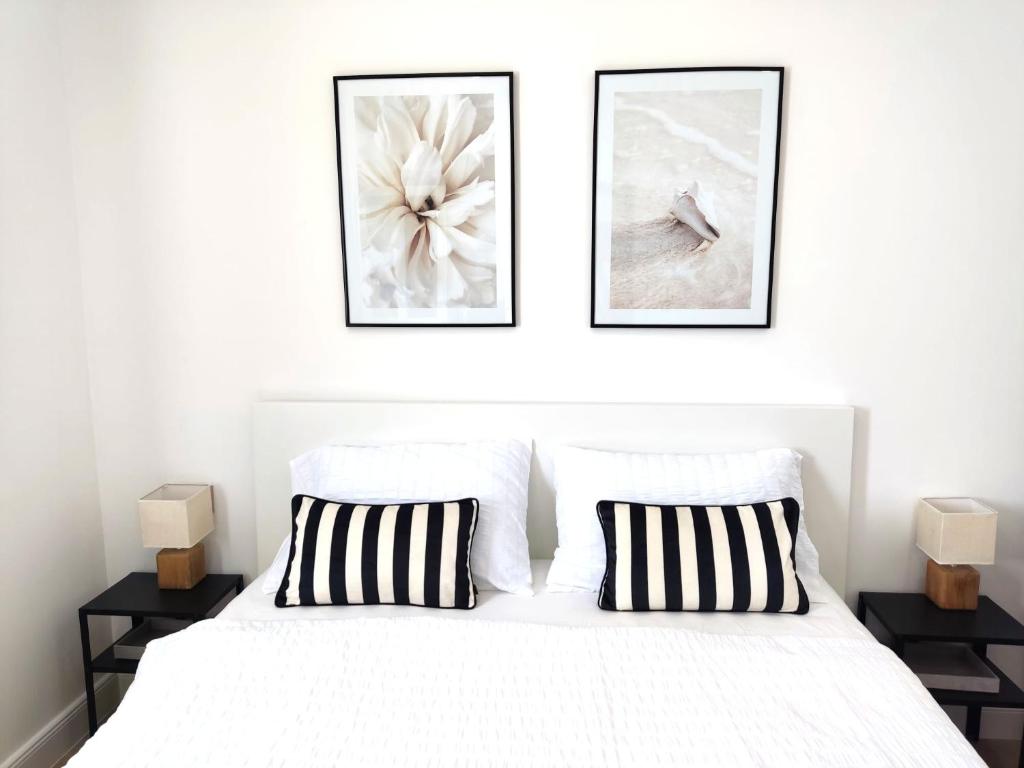 a bedroom with a white bed with two pictures on the wall at Mina Lux Jelsa in Jelsa