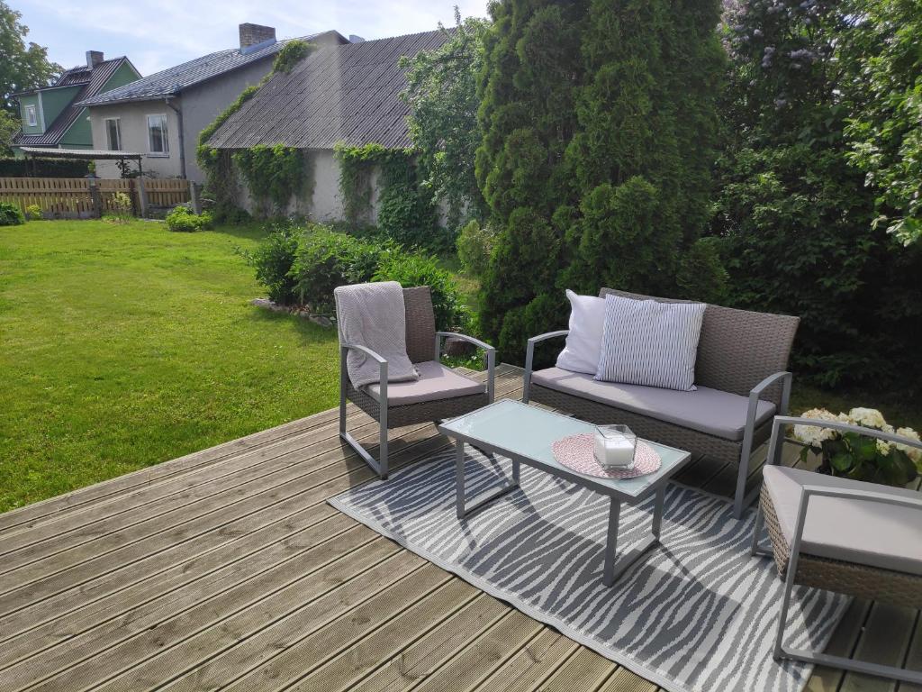 a patio with two chairs and a table on a deck at Sireli hubane maja oma aia ja kaminaga in Haapsalu
