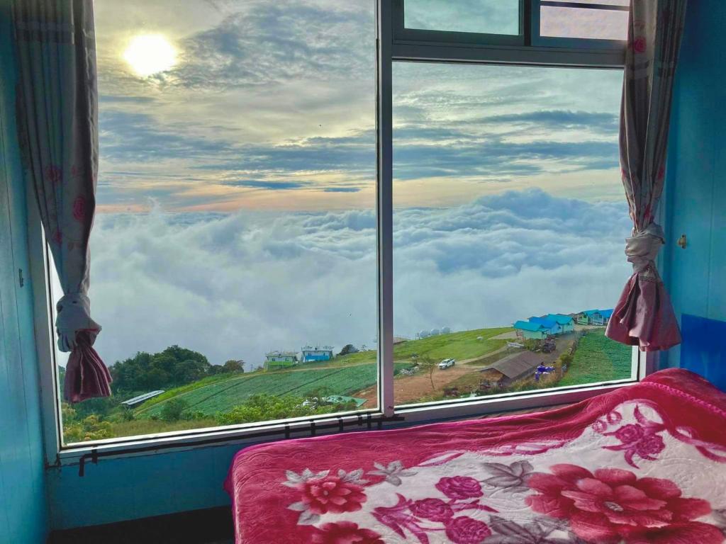 una finestra con vista sulle montagne di วิมานหมอก ภูทับเบิก a Ban Maeo Thap Boek
