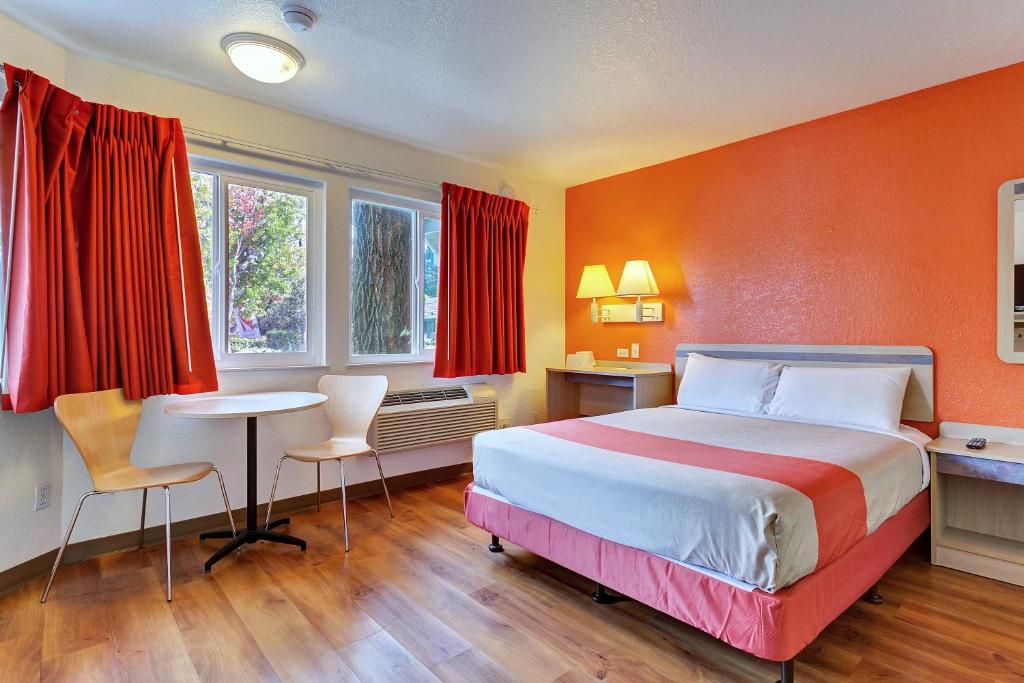 a hotel room with a bed and a table and chairs at Motel 6-Rohnert Park, CA in Rohnert Park