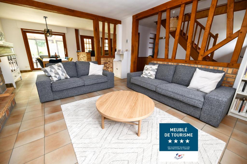 Una sala de estar con dos sofás y una mesa de café. en La Villa aux Oliviers, en Eu