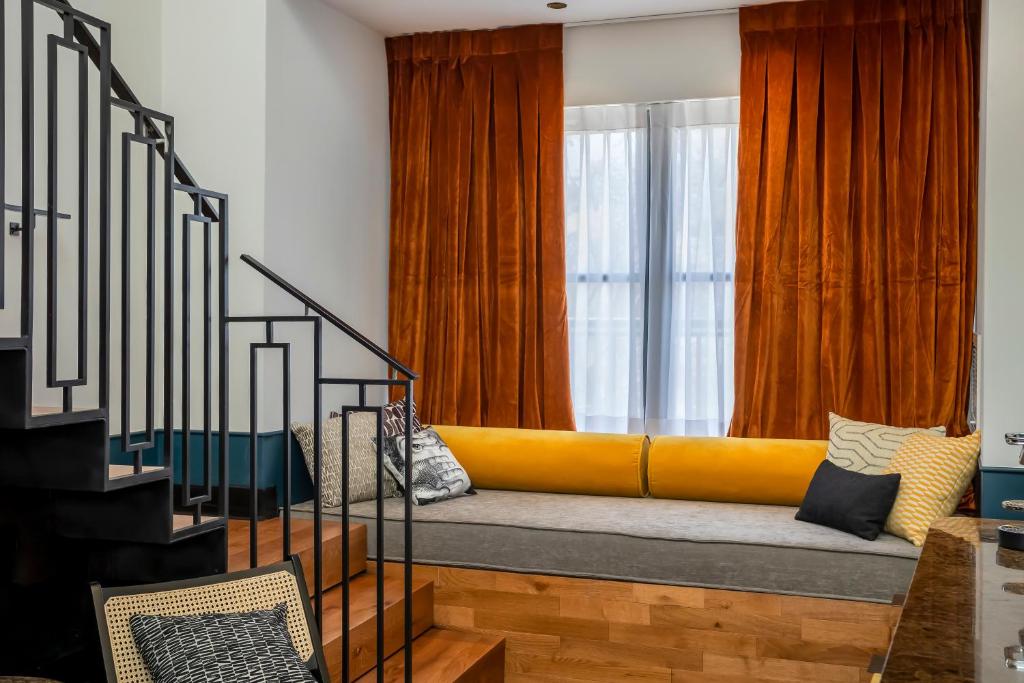 a yellow couch in a room with a window at Backstage Hotel - an Atlas Boutique Hotel in Tel Aviv