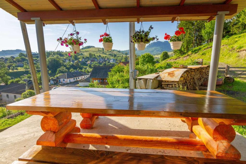 a wooden table on a porch with a view of a valley at Садиба під Лісом in Volovets