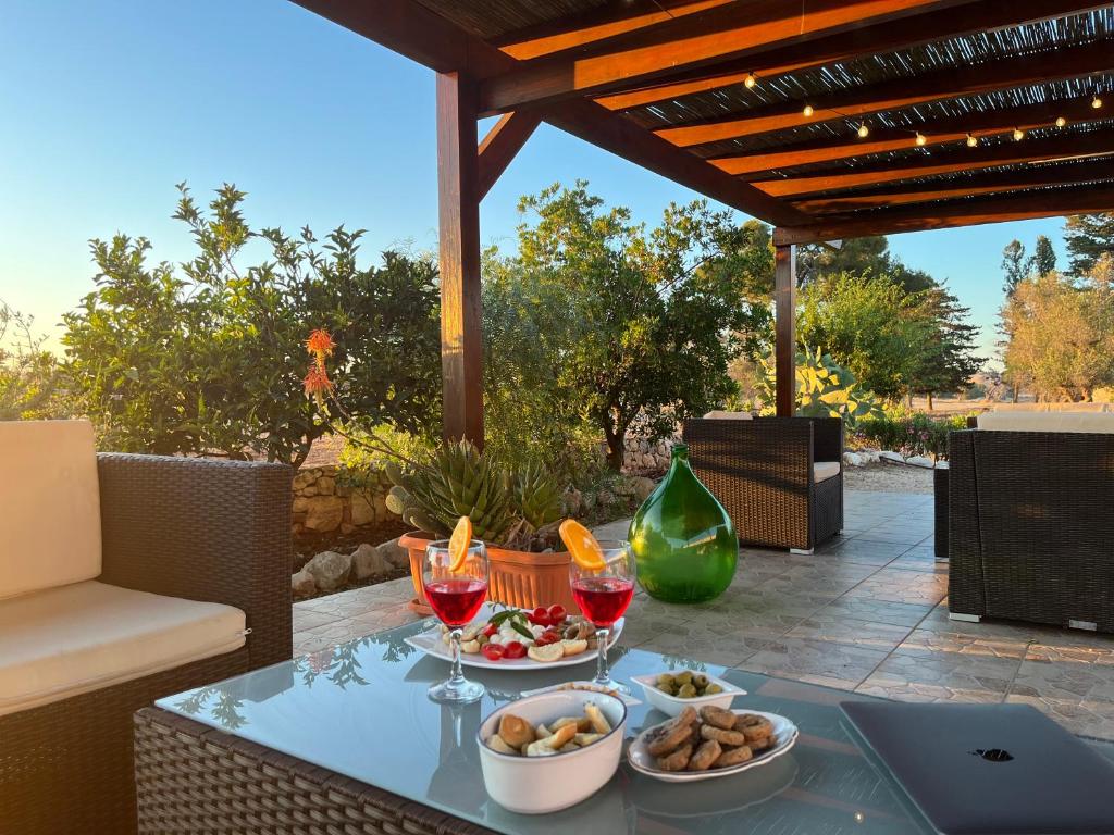 einen Tisch mit Weingläsern und Speisen auf einer Terrasse in der Unterkunft Tenuta Ingegna Apartments in Porto Cesareo