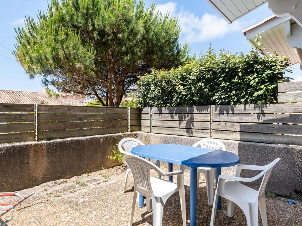 niebieski stół, dwa białe krzesła i drzewo w obiekcie Maison T3 proche plage & centre-ville avec jardinet et parking - FR-1-521-200 w mieście Biscarrosse