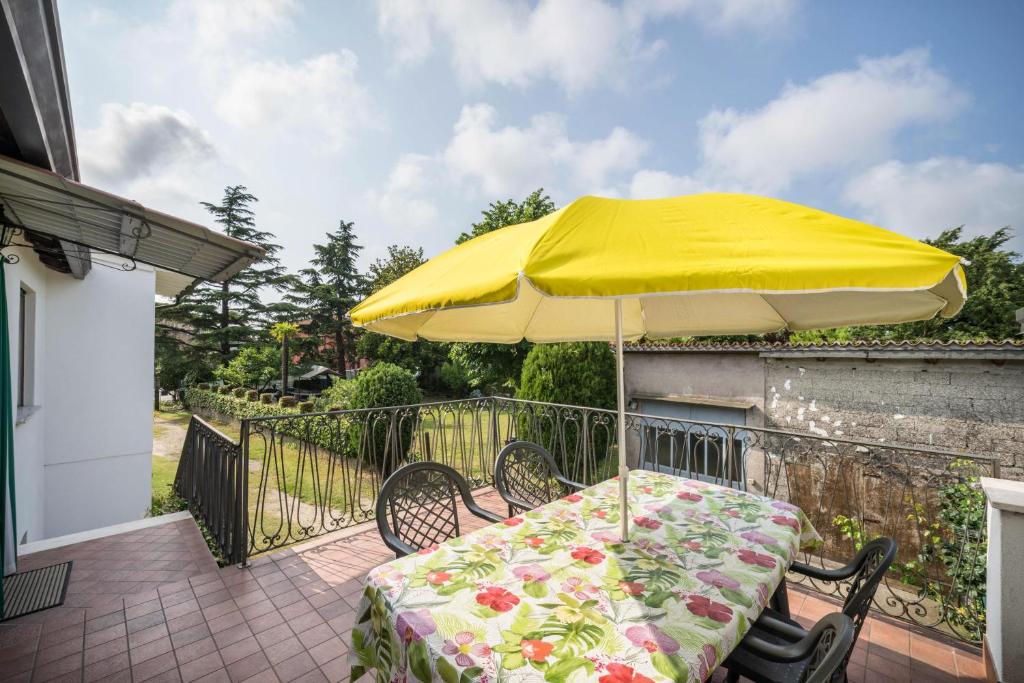 uma mesa com um guarda-chuva amarelo num pátio em Casa vacanze Bergamo em Cavallino-Treporti