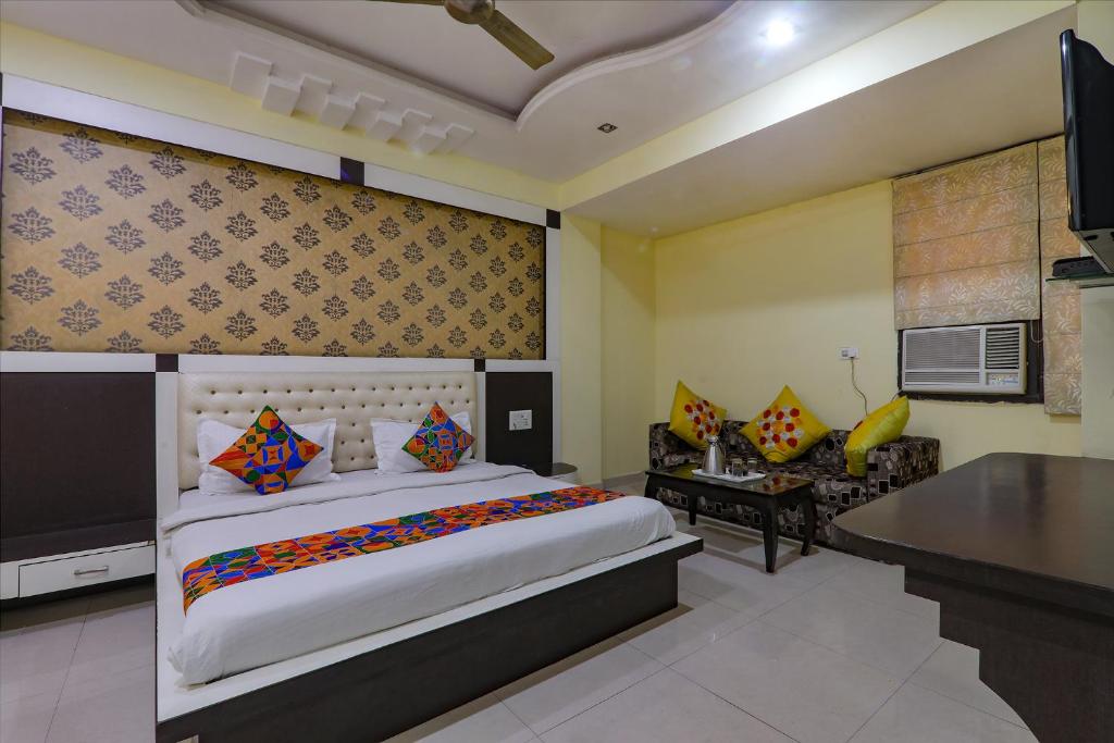 a bedroom with a large bed and a desk at FabHotel Govinda Royal in Kānpur