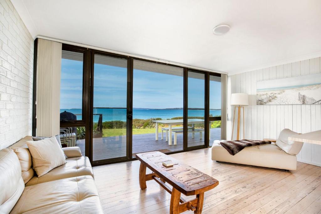 a living room with a view of the ocean at Azure Absolute Beachfront I Pet Friendly in Callala Beach