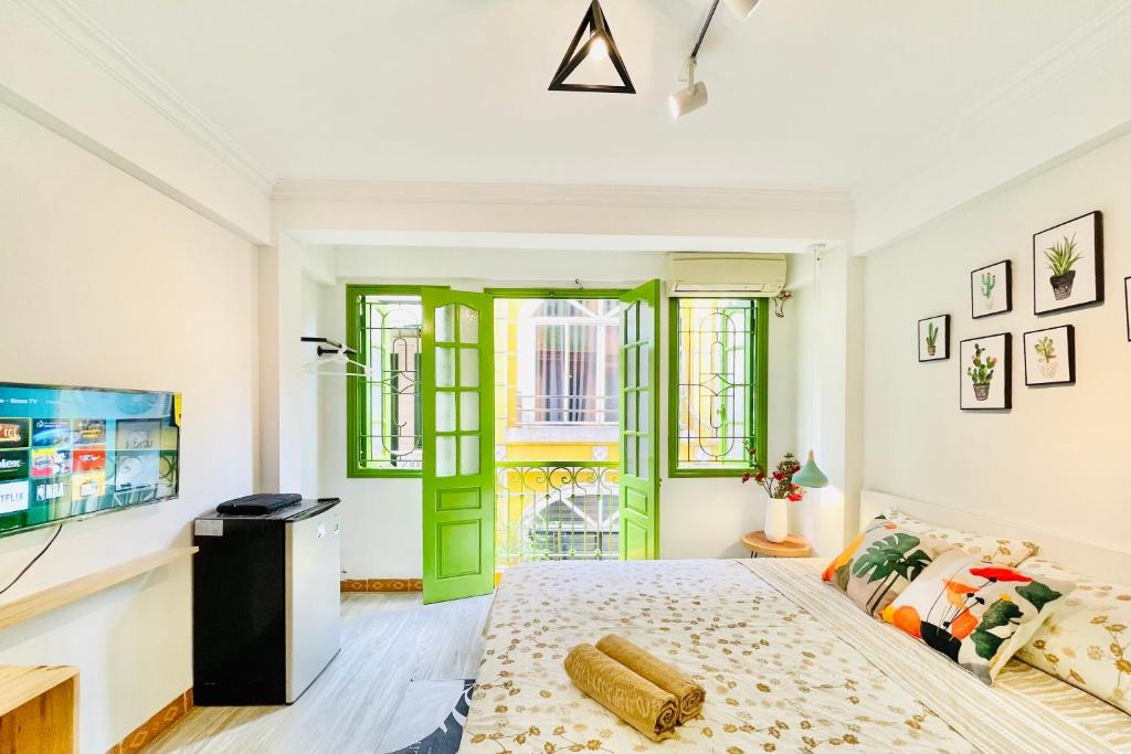 a bedroom with a green door and a bed at Vitamin Home Hoàn Kiếm 35 in Hanoi