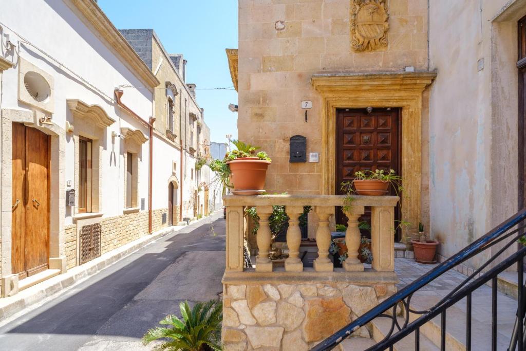 a street in an old town with potted plants on a balcony at Casa vacanza Il Giglio in Manduria