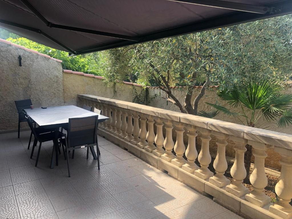 a table and chairs sitting under an umbrella on a patio at Maison la Londe in La Londe-les-Maures