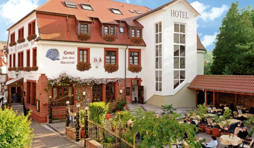 hotel z ludźmi siedzącymi poza nim w obiekcie L´Antica Ruota - Zum Alten Wasserrad w mieście Annweiler am Trifels