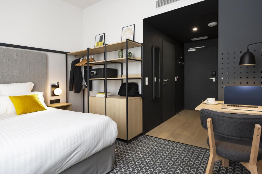- une chambre avec un lit et un bureau avec un ordinateur portable dans l'établissement Odalys City Le Havre Centre Gare, au Havre