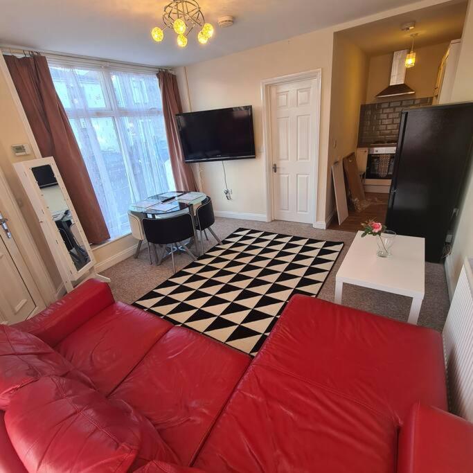 - un salon avec un canapé rouge et un sol en damier dans l'établissement Groundfloor One Bedroom Apartment, à Ryde