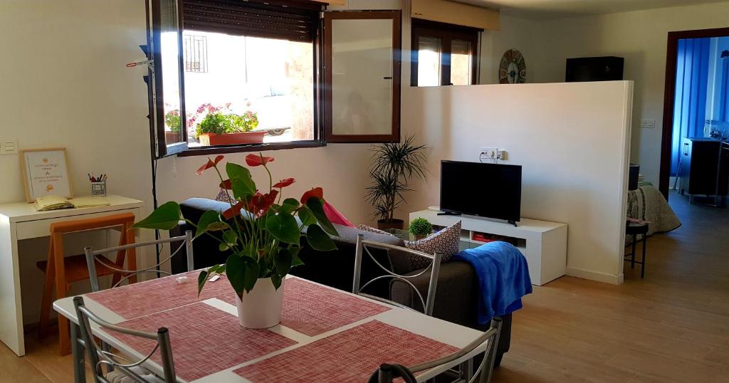 sala de estar con mesa y TV en El Rodeno de Gea Ideal parejas, en Gea de Albarracín