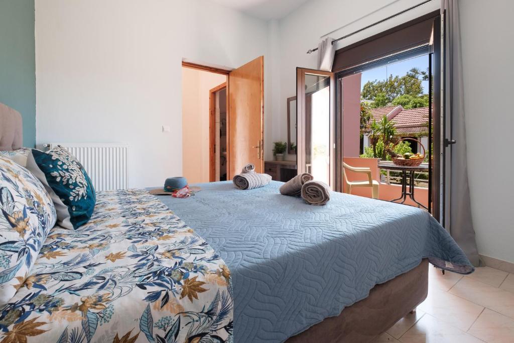 sypialnia z łóżkiem i balkonem z widokiem na okolicę w obiekcie Mouzakitis Apartments 4 w mieście Arillas