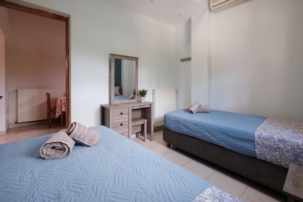 sypialnia z 2 łóżkami, komodą i lustrem w obiekcie Mouzakitis Apartments 4 w mieście Arillas