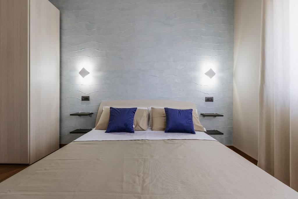 APULIA BLUE APARTEMENTS & B&B في باري: غرفة نوم بسرير كبير مع وسائد زرقاء