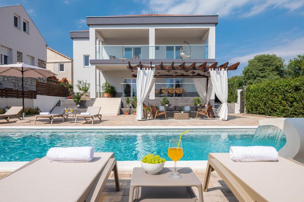 a villa with a swimming pool and a house at Villas Pakoštane in Pakoštane
