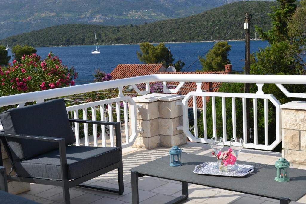 a patio with a chair and a table with wine glasses at Cherry in Korčula