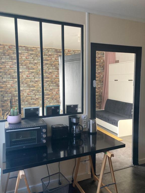 a living room with a table with a microwave at L'INTEMPOREL - A 300m de la gare de Tours in Tours
