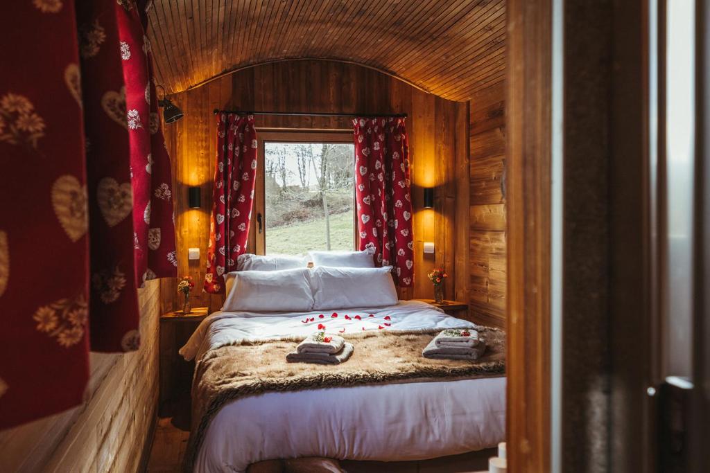 ein Schlafzimmer mit einem Bett in einem Zimmer mit einem Fenster in der Unterkunft La RouLodge du Veilleur - Hôtel Insolite in Ermeton-sur-Biert
