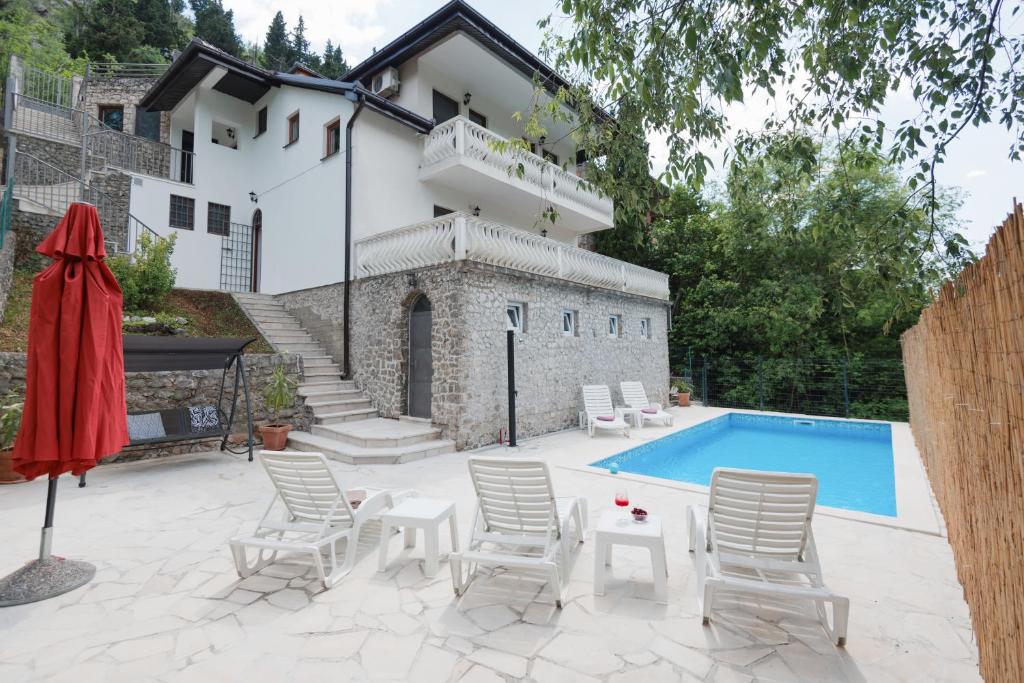 a patio with a pool and chairs and a house at Villa Old Town Stolac in Stolac