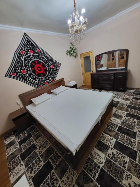 Bett in einem Zimmer mit Kronleuchter in der Unterkunft Hotel Motrid in Samarkand