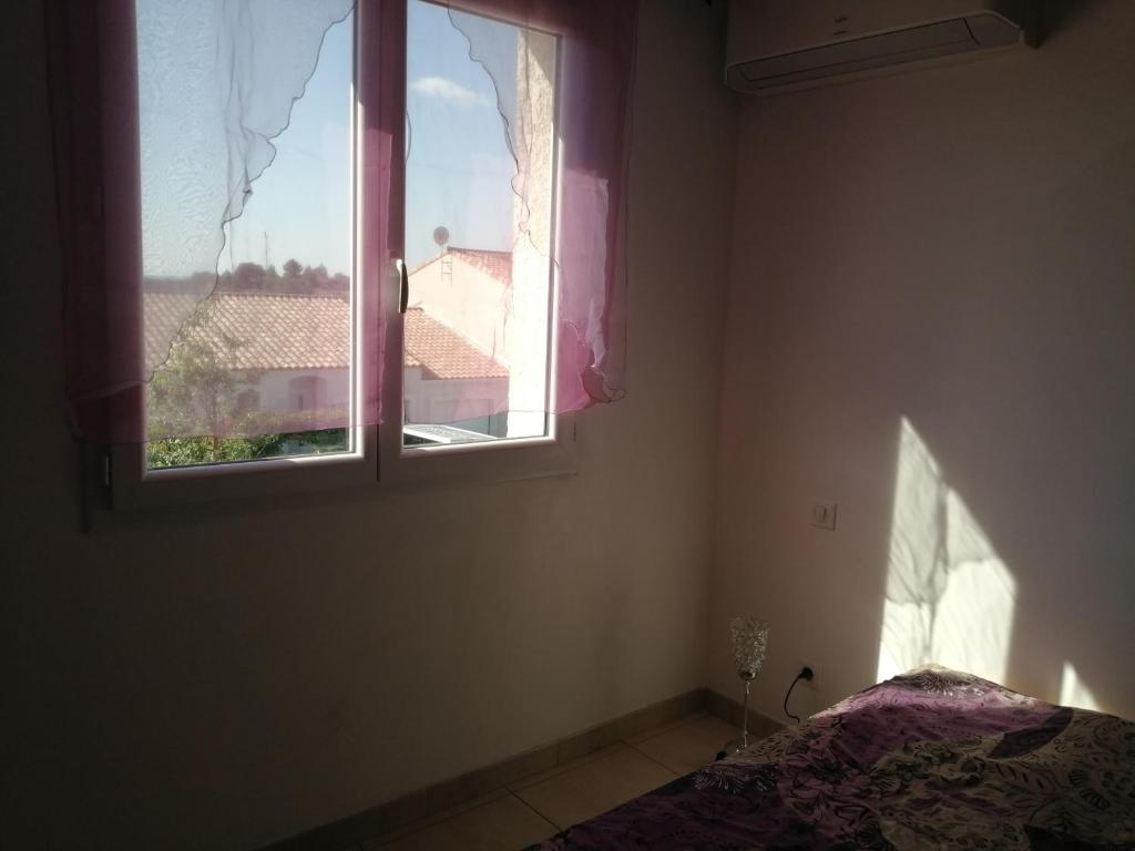 Habitación vacía con ventana y cama en EVANA, en Bize-Minervois