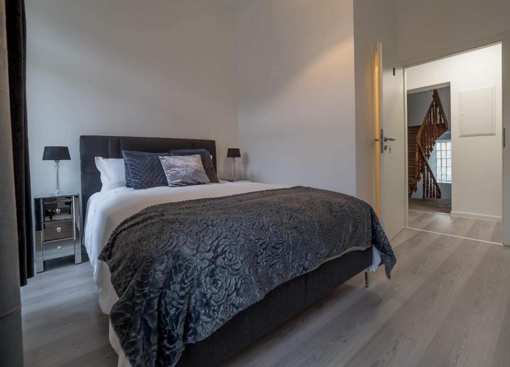 ein Schlafzimmer mit einem großen Bett mit einer schwarzen Decke in der Unterkunft EXECUTIVE DOUBLE ROOM WITH EN-SUITE IN GUEST HOUSE CITY CENTRE r4 in Luxemburg (Stadt)