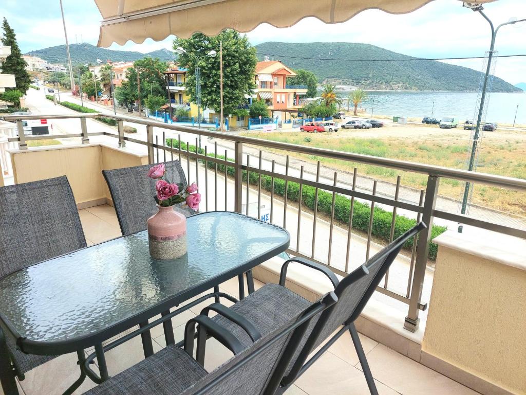 a table and chairs on a balcony with a view at Myrsini’s sea view apartment in Nea Peramos
