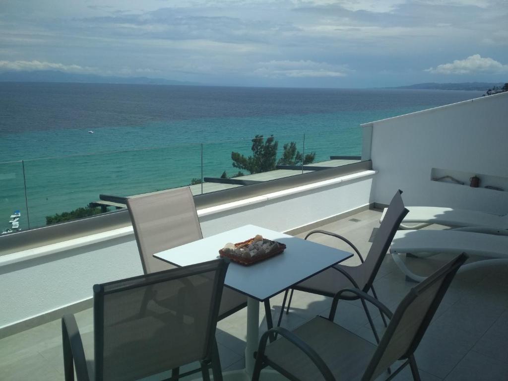 d'une table et de chaises sur un balcon donnant sur l'océan. dans l'établissement Myrto 's sea view, à Kallithéa Halkidikis