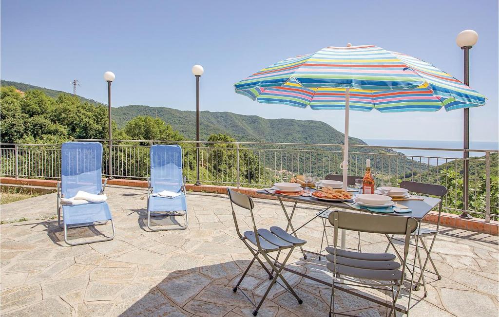 einen Tisch mit Stühlen und einem Sonnenschirm auf einer Terrasse in der Unterkunft Casa Del Papavero in Bracco