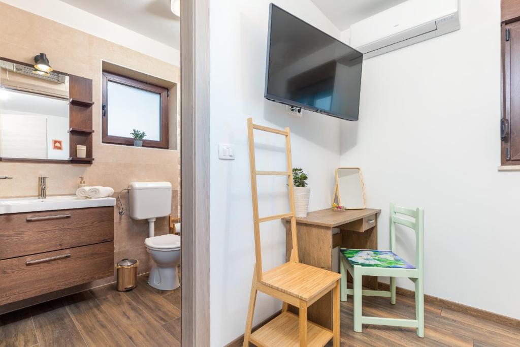 łazienka z umywalką i toaletą oraz telewizor w obiekcie Rental house Nada w Fažanie