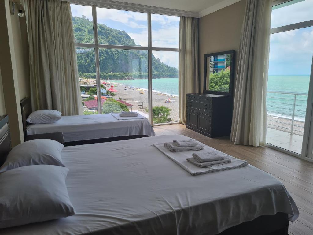 two beds in a room with a view of a beach at Black Sea Hotel in Kvariati