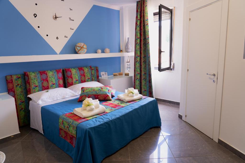 L'Orologio Guest Rooms في سكاليا: غرفة نوم عليها سرير وفوط